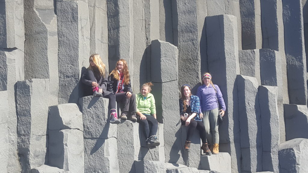 Travel Troop climbs on the basalt columns